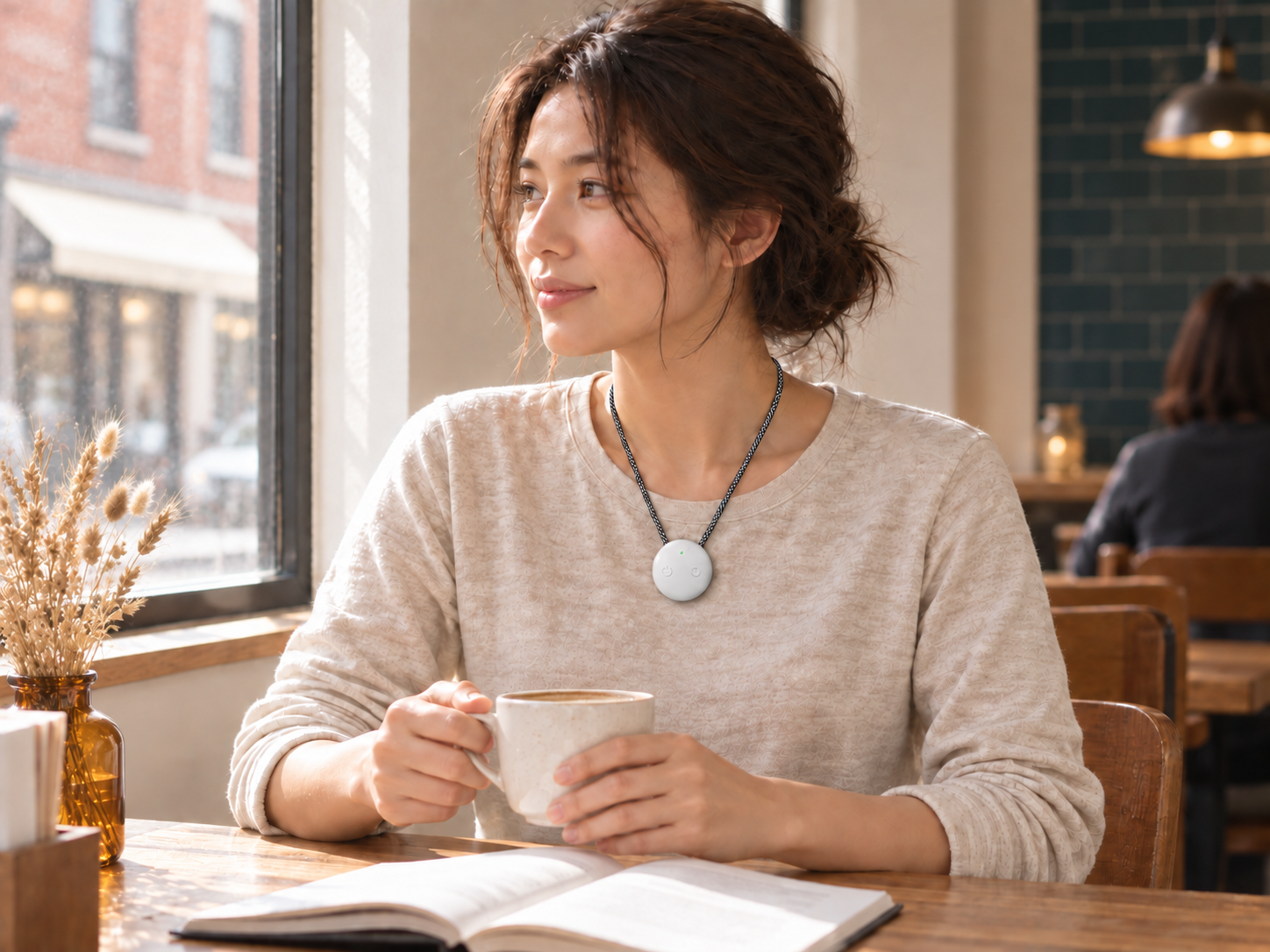 A woman relaxing in a cafe with white AMOFIT worn over her oatmeal top