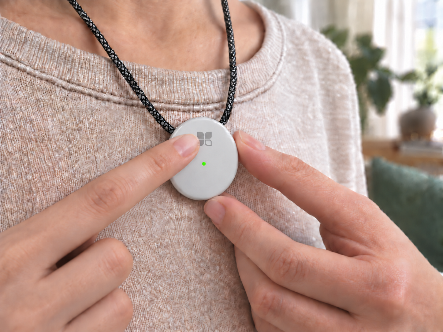 Pressing the power button on a white AMOFIT S worn over clothing